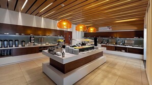A modern breakfast buffet with various food stations, including a fruit bowl, coffee dispensers, and a buffet counter with plates and utensils. - Holiday Inn Express M érida by IHG (Mérida)