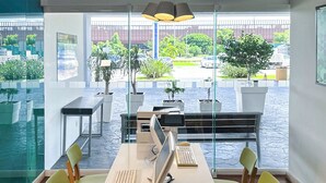 A modern office space with a long table, four chairs, a computer, and a printer. - Holiday Inn Express Mérida by IHG (Mérida)