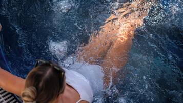 A person swimming in a pool with a piano visible in the foreground.