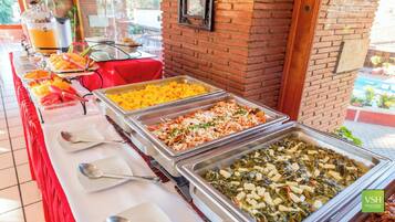Un buffet proposant une variété de plats, notamment du riz, un plat de légumes et un plat de viande.