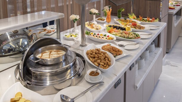 A buffet with various dishes and a coffee station. - Corp Executive Hotel Doha Suites (Doha)
