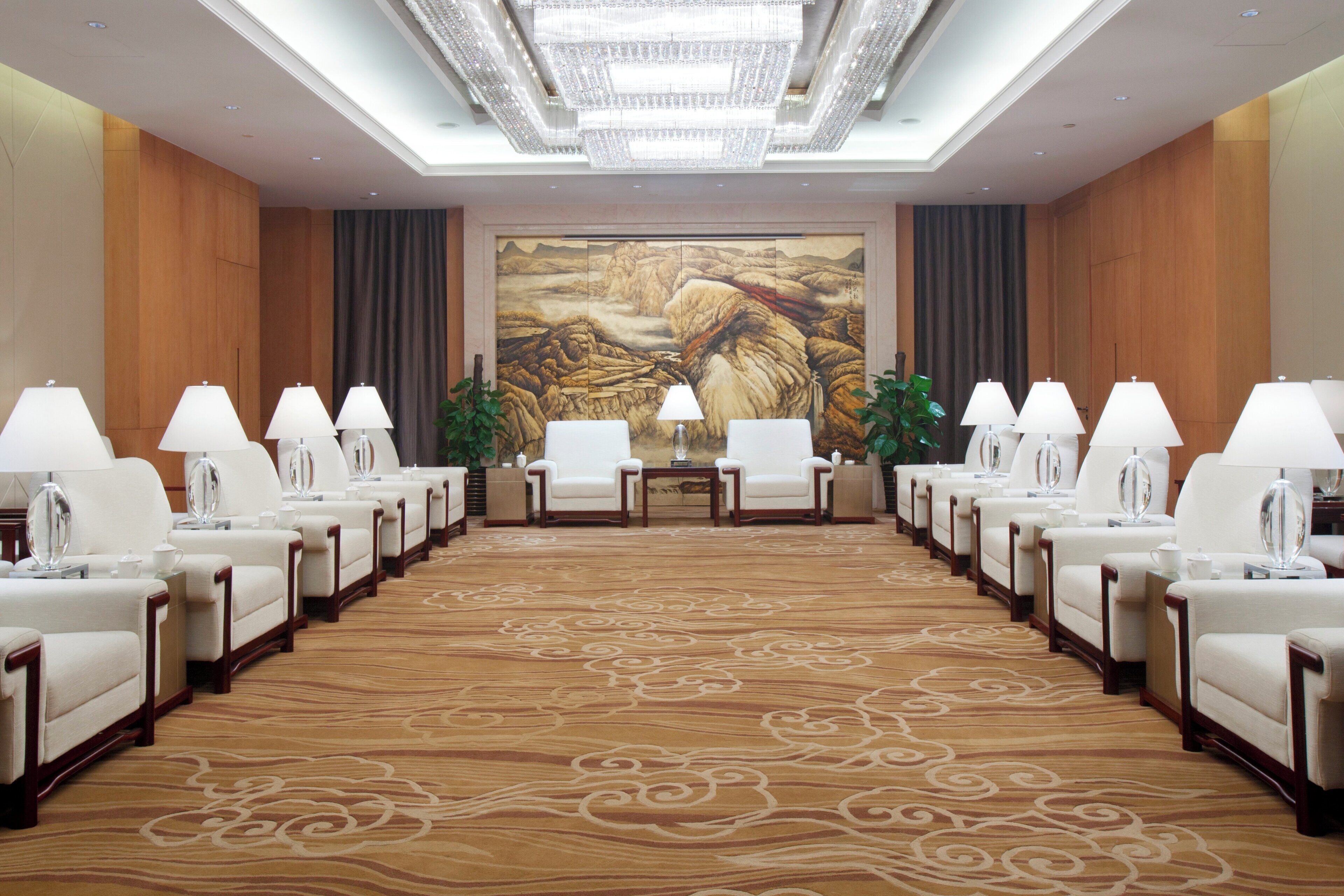 A conference room with a long table, chairs, and lamps.