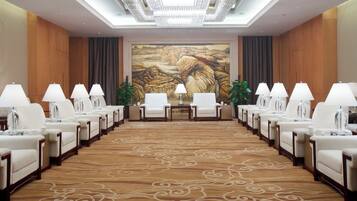 A conference room with a long table, chairs, and lamps.