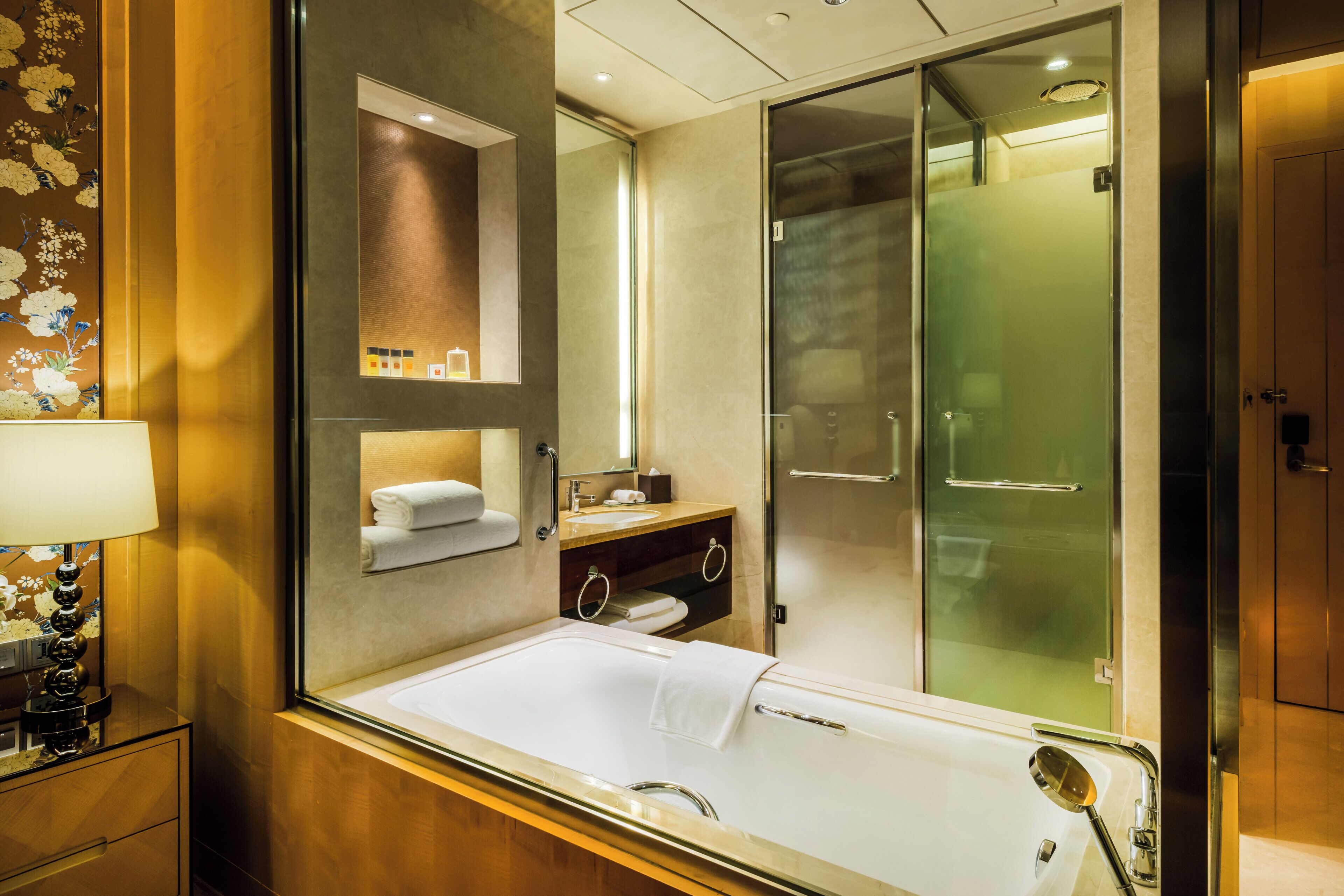 A modern bathroom with a bathtub, a glass shower enclosure, and a vanity with a mirror.