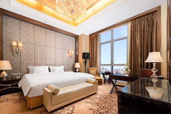 A spacious hotel room with a large bed, a desk, a chair, and a view of the city through large windows. - Crowne Plaza Xiangyang by IHG (Xiangyang)