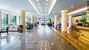A spacious lobby with a polished granite floor, large columns, and a reception desk with a plant. - Aiyara Palace (Pattaya)