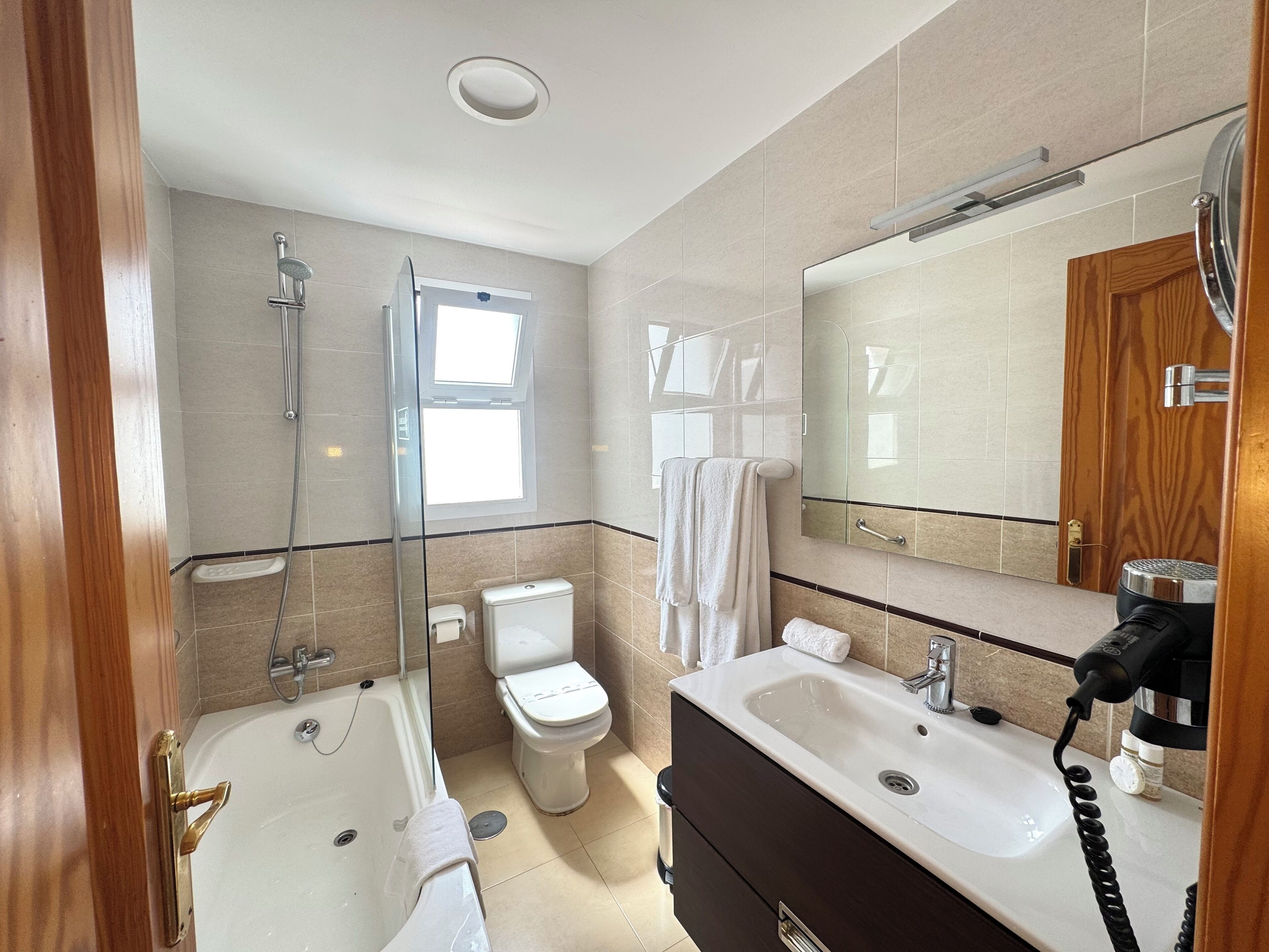A modern bathroom with a bathtub, toilet, and sink.