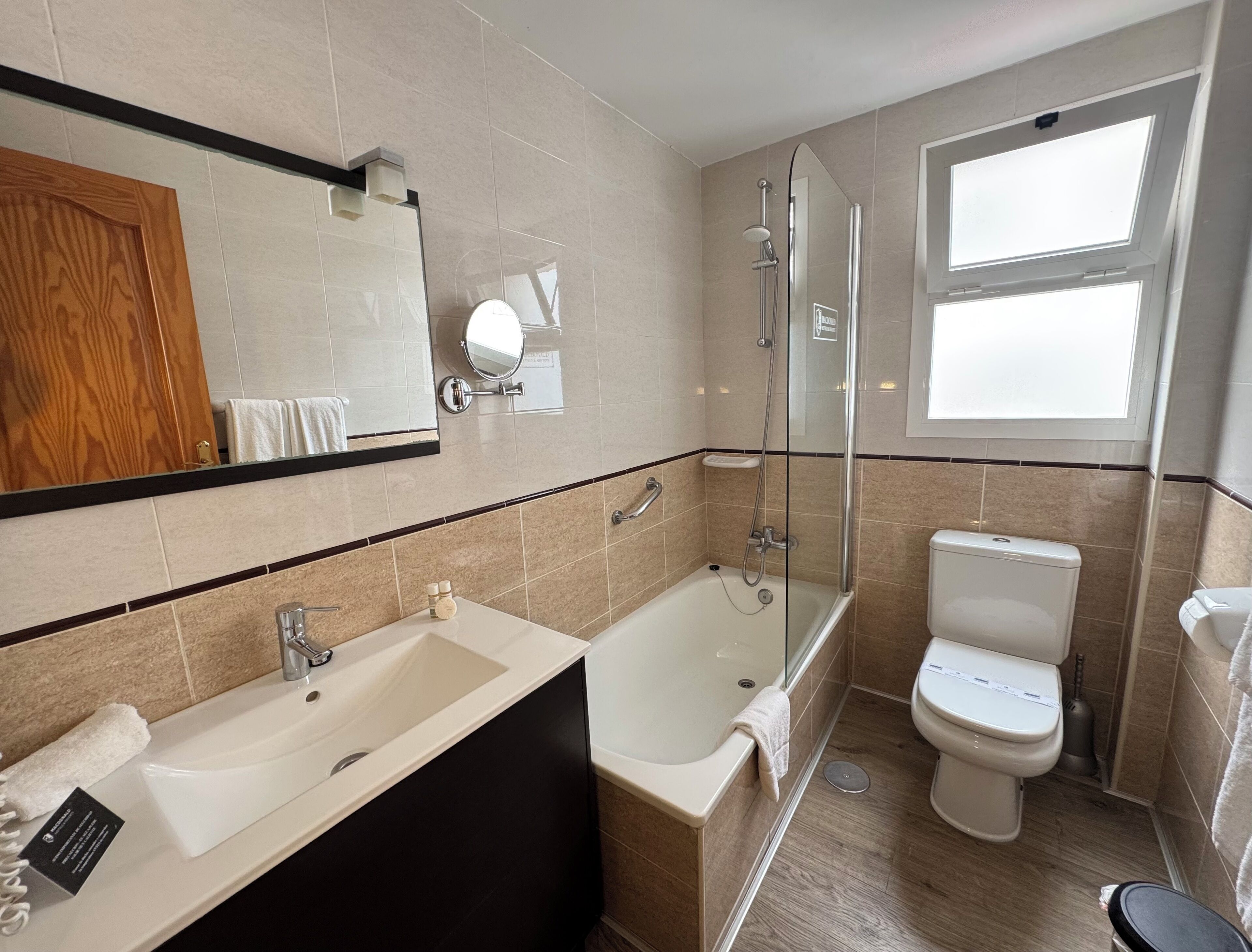Een moderne badkamer met een bad, toilet en wastafel.
