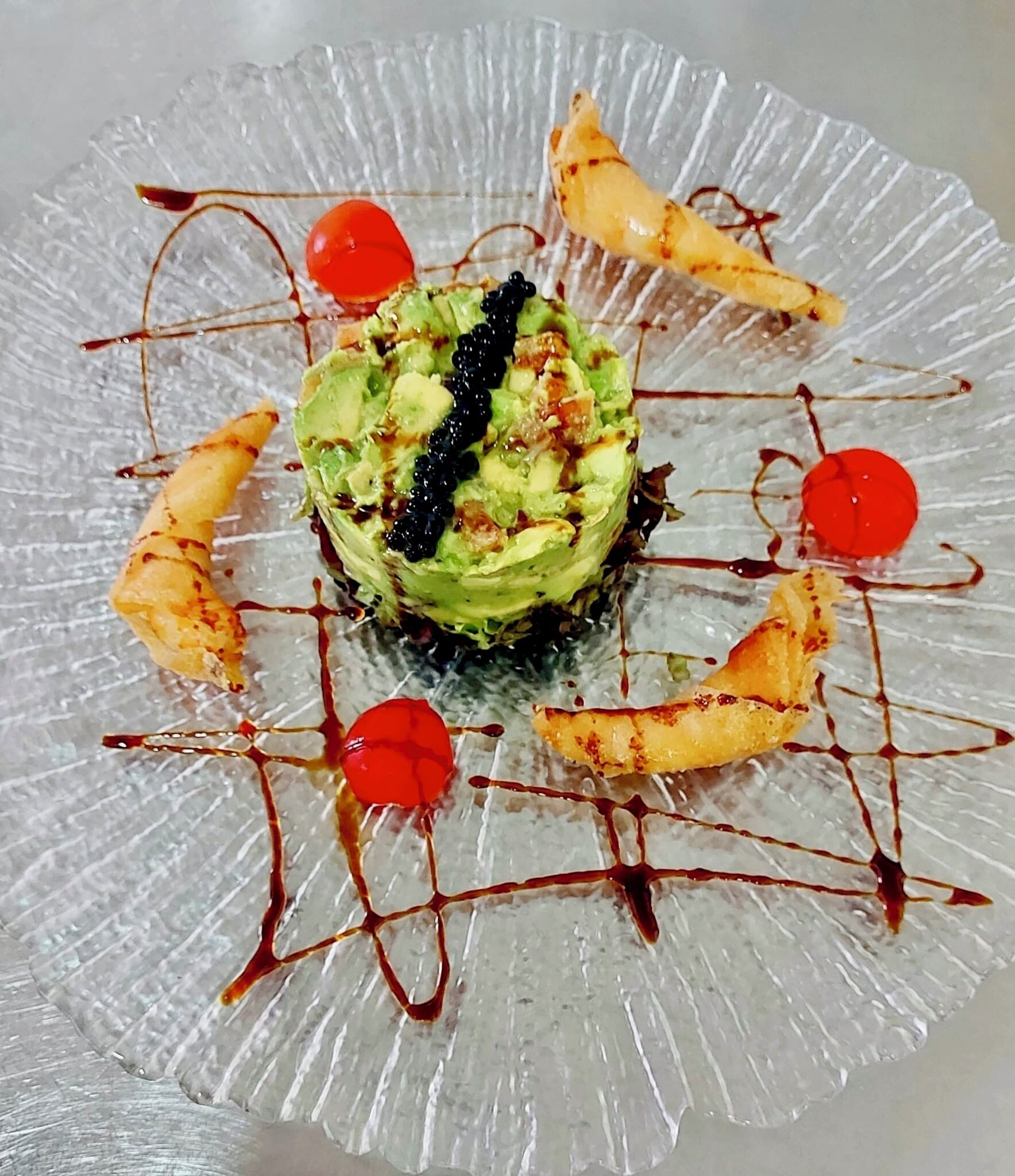 Un dessert présenté sur une assiette en verre transparent, dont le bord est légèrement texturé.