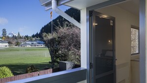 A balcony with a view of a green field and mountains. - Bella Vista Queenstown (Queenstown)