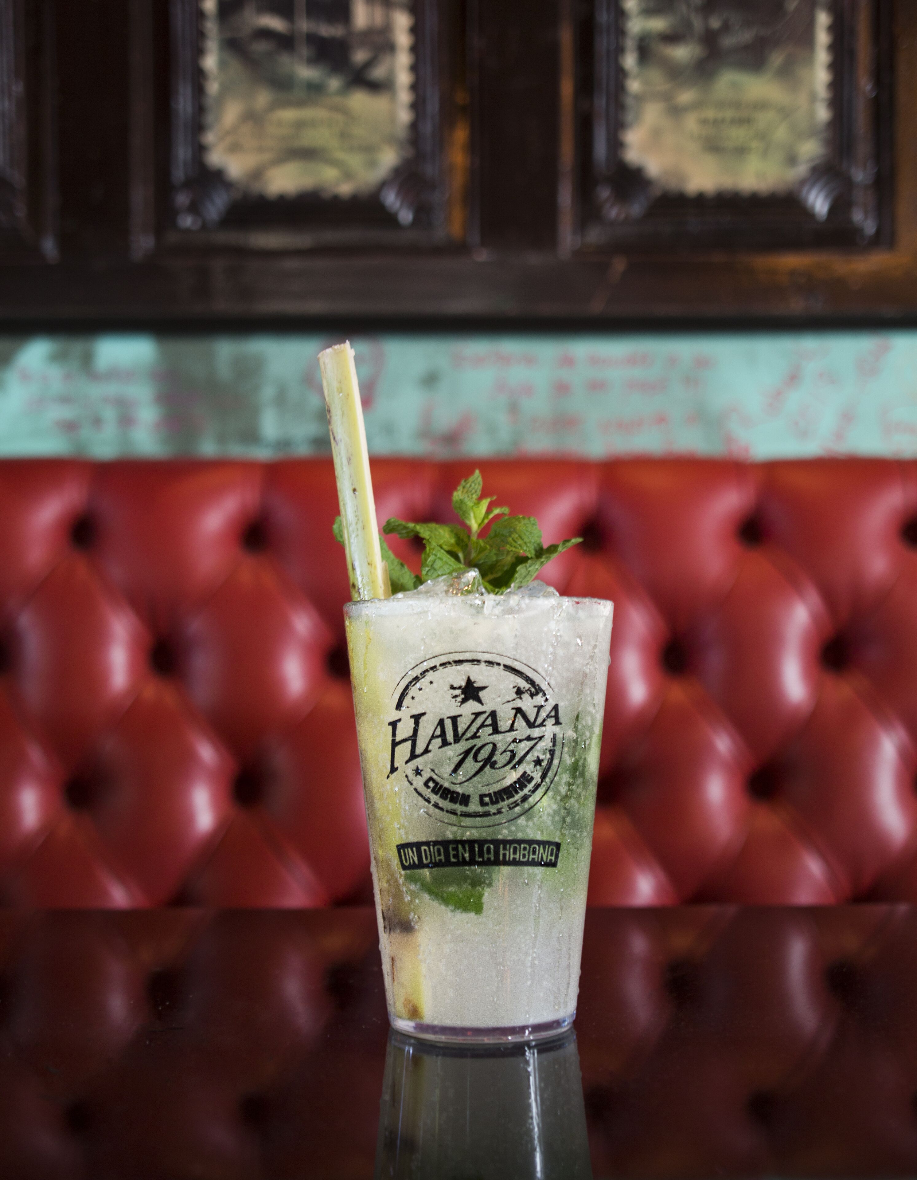 A glass of Havana 1957 cocktail with mint garnish on a reflective surface.