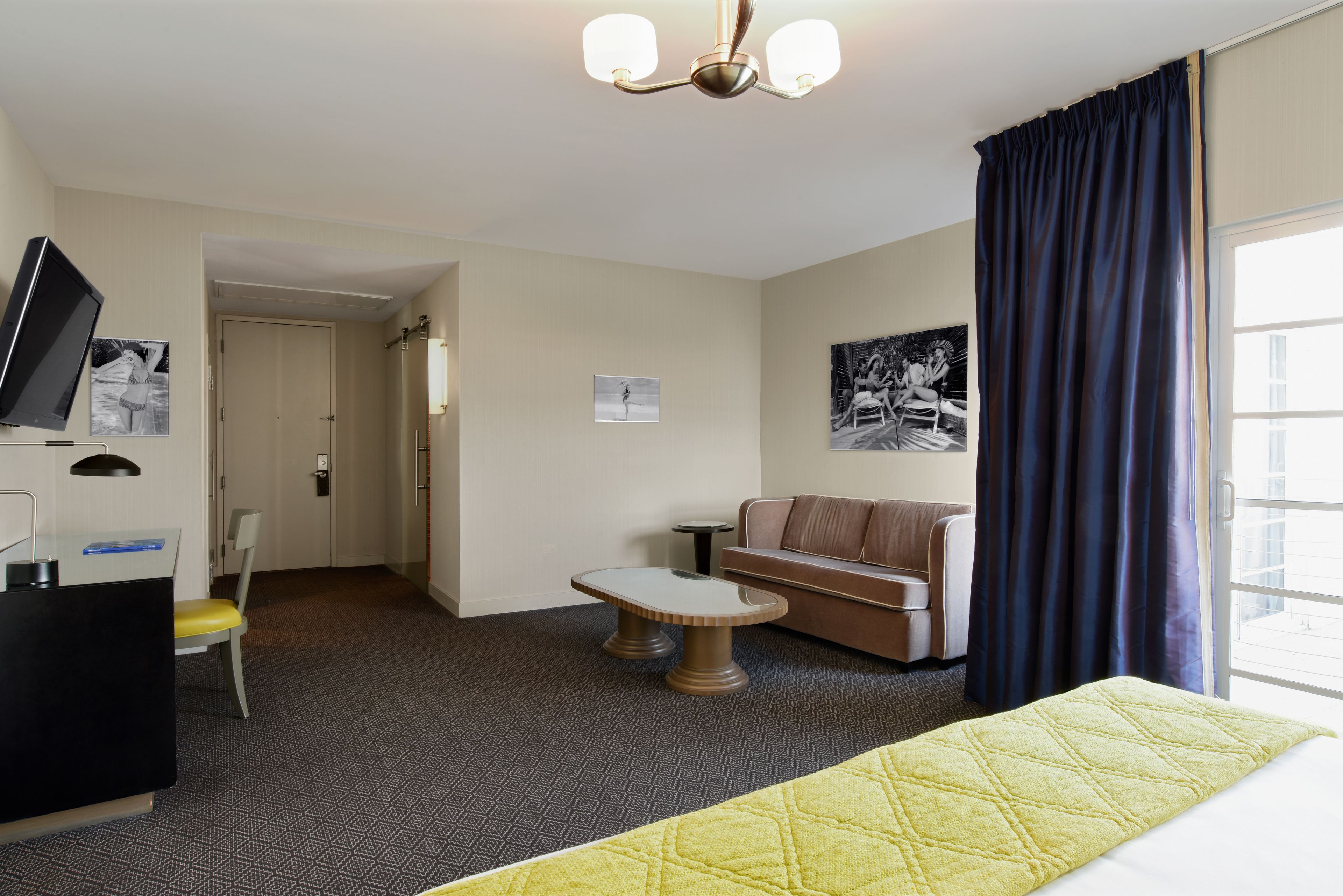 Hotelkamer met een bed, bureau, stoel, klein tafeltje, bank en televisie.