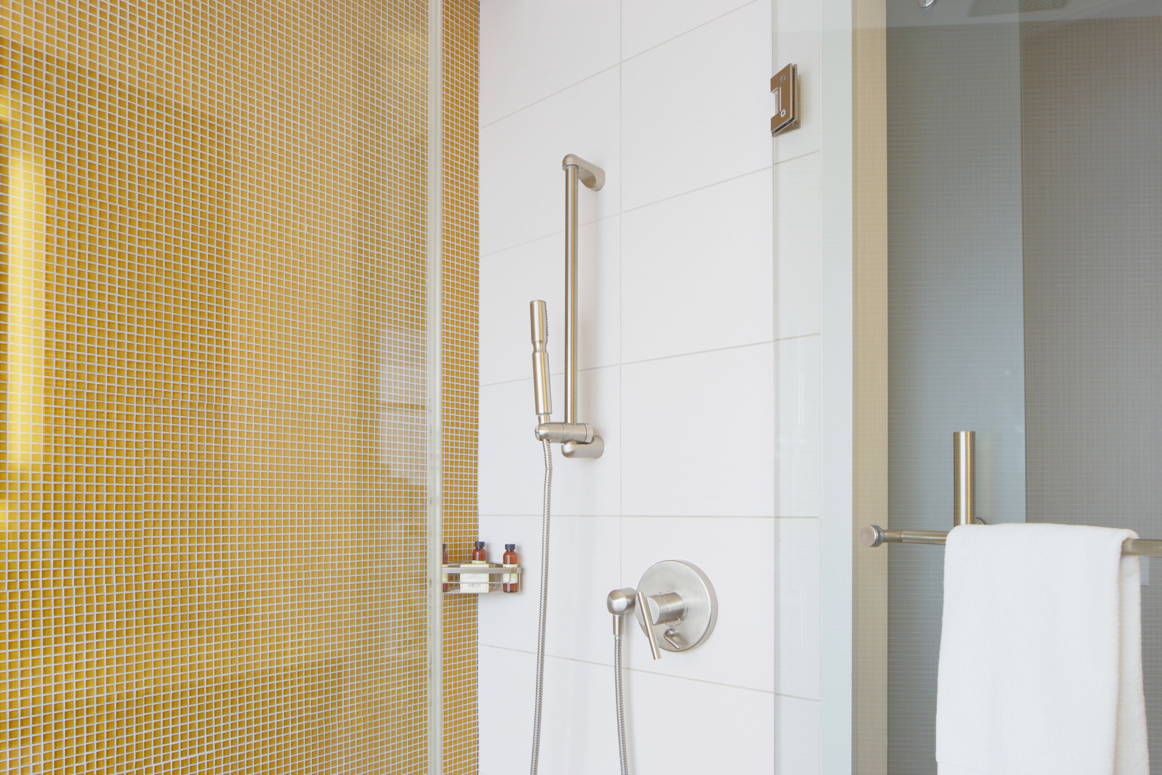 A bathroom with a shower, a towel rack, and a toilet.