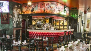 Un ristorante con un lungo tavolo imbandito per un pasto, circondato da sedie.