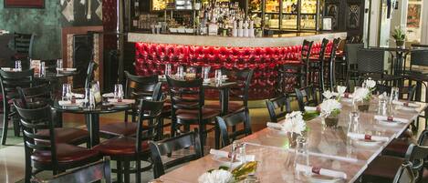 A restaurant with a long dining table set for a meal, surrounded by chairs.