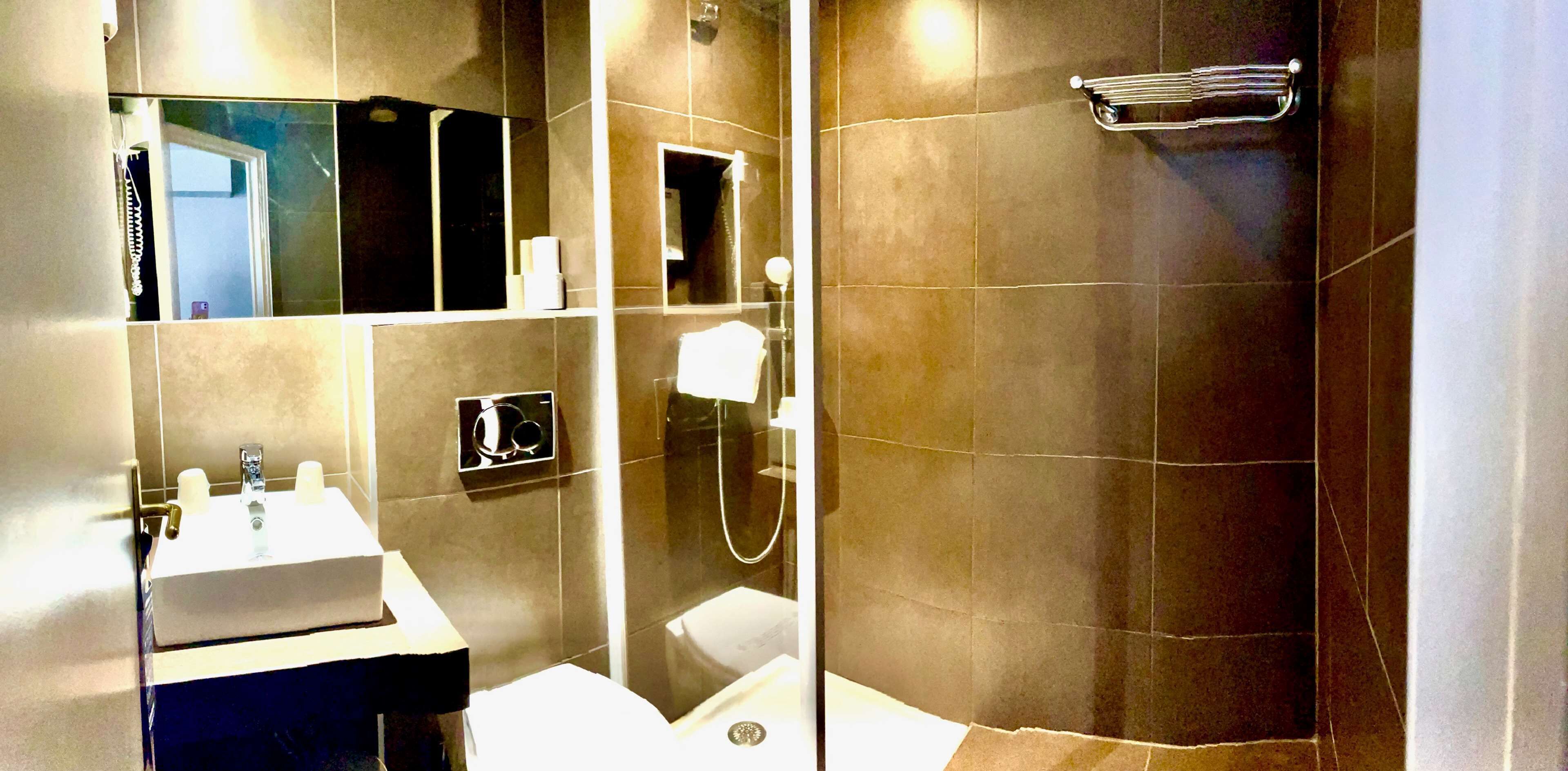 Une salle de bain moderne avec un lavabo, un miroir et une douche.