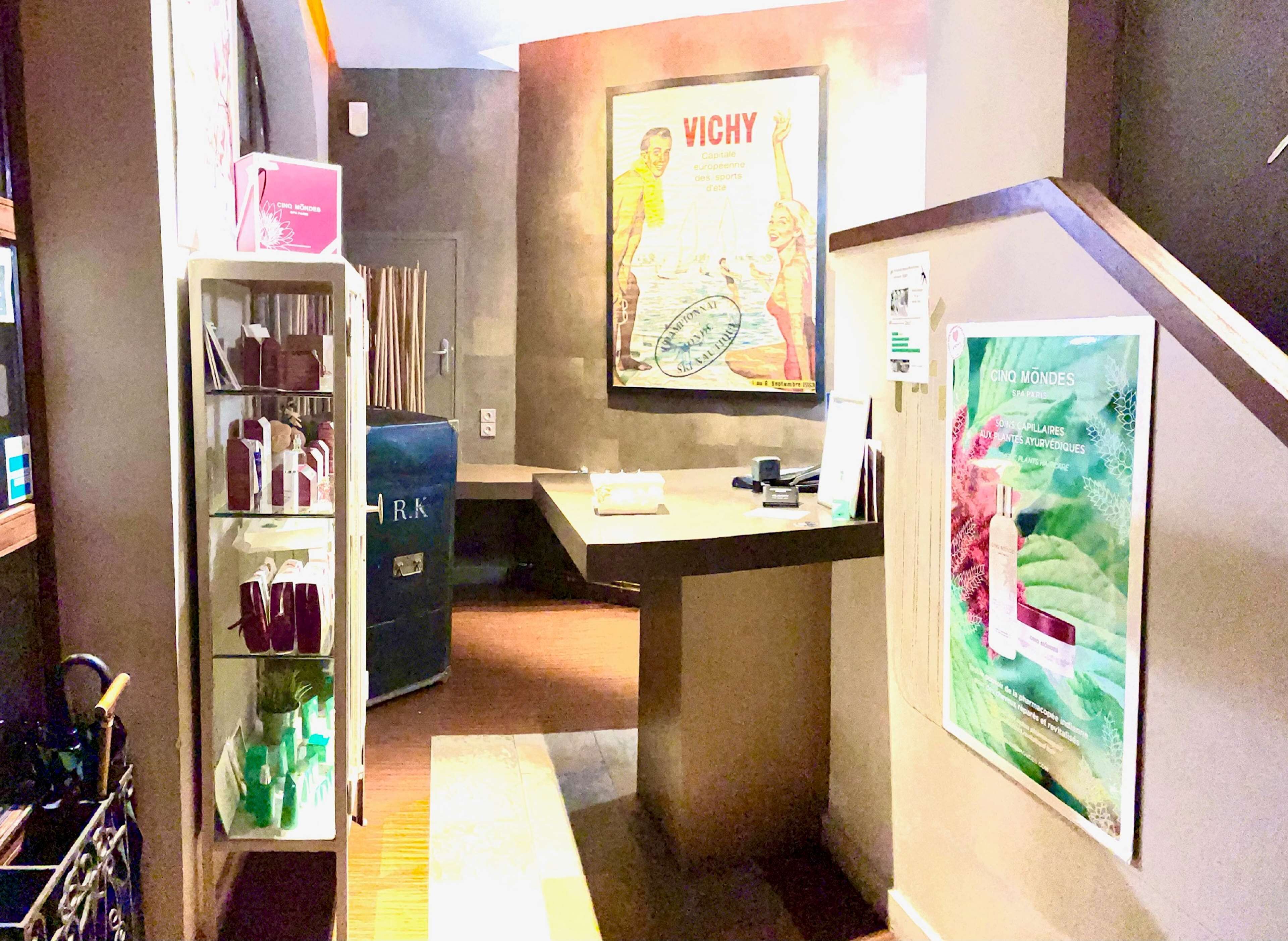 A reception area with a counter, a shelf with various items, and a poster on the wall.