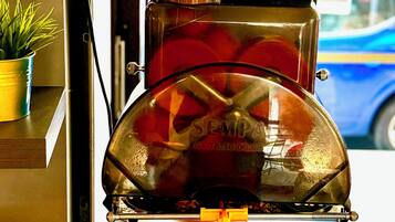 Une machine à café avec un panier rempli d’oranges posé sur le dessus.