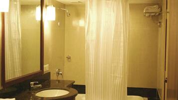A bathroom with a sink, mirror, shower, and bathtub.