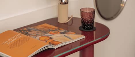 Una revista sobre una mesa de vidrio con un candelabro cerca.