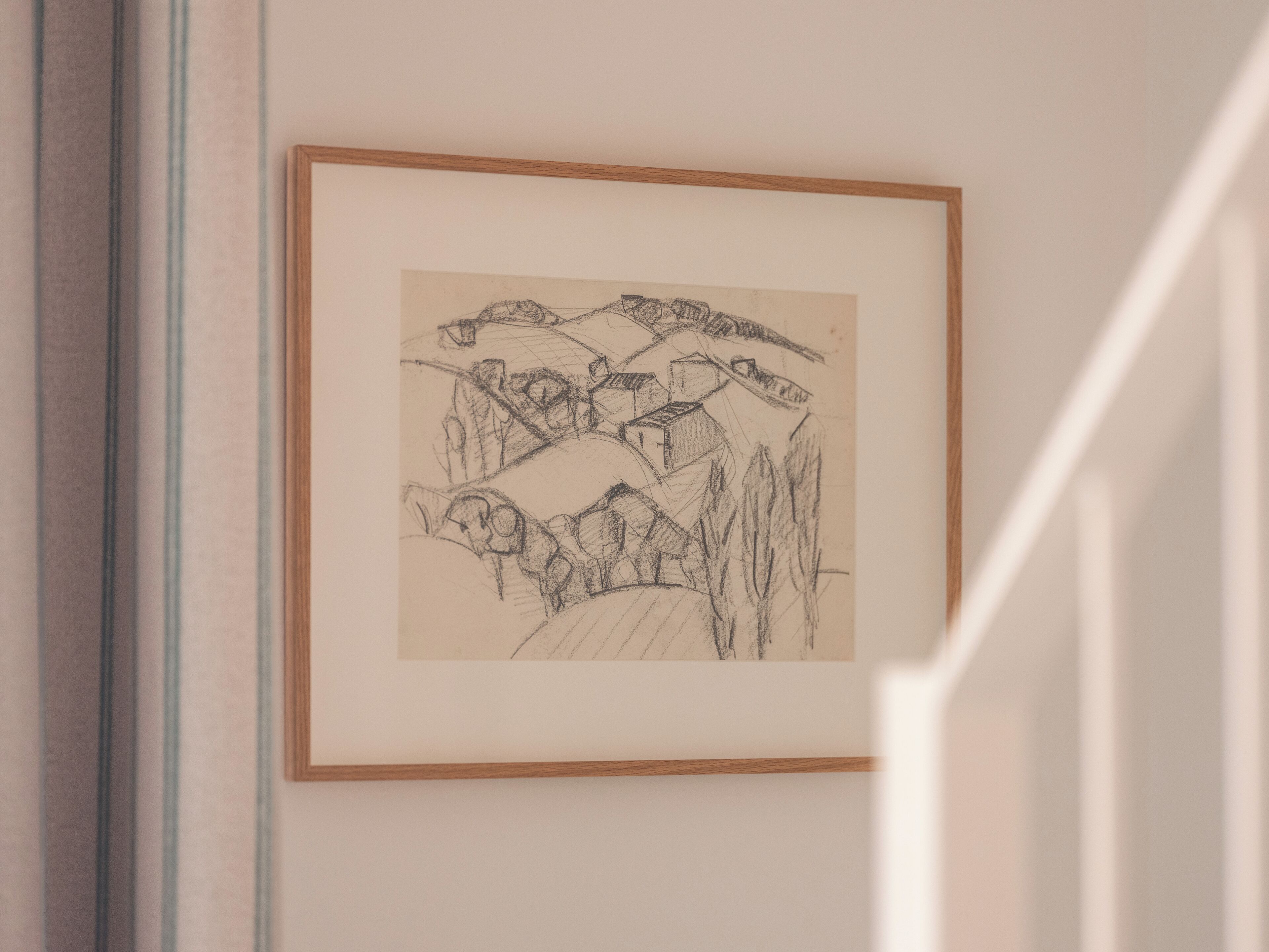 Un boceto enmarco de un paisaje montañoso con construcciones en las laderas.