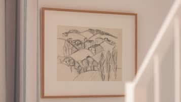 A framed sketch of a mountainous landscape with buildings on the slopes.