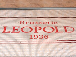 A tiled floor with the inscription "Brasserie LEOPOLD 1936". - Hôtel Saint Christophe Aix en Provence Centre Ville by Germain Collection (Aix-en-Provence)