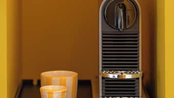 Una cafetera con dos tazas sobre una bandeja en una habitación amarilla.