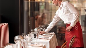 Un restaurante con un camarero atendiendo una mesa.