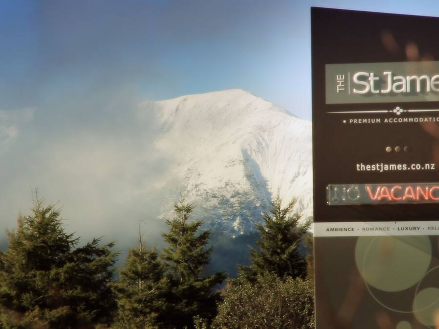 A sign for The St James with a view of a snow-capped mountain in the background.