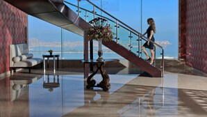 A modern lobby with a glass staircase, a decorative table, and a sofa. - Two Seasons Hotel & Apartments (Dubai)