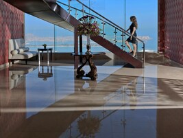 A modern lobby with a glass staircase, a decorative table, and a sofa.