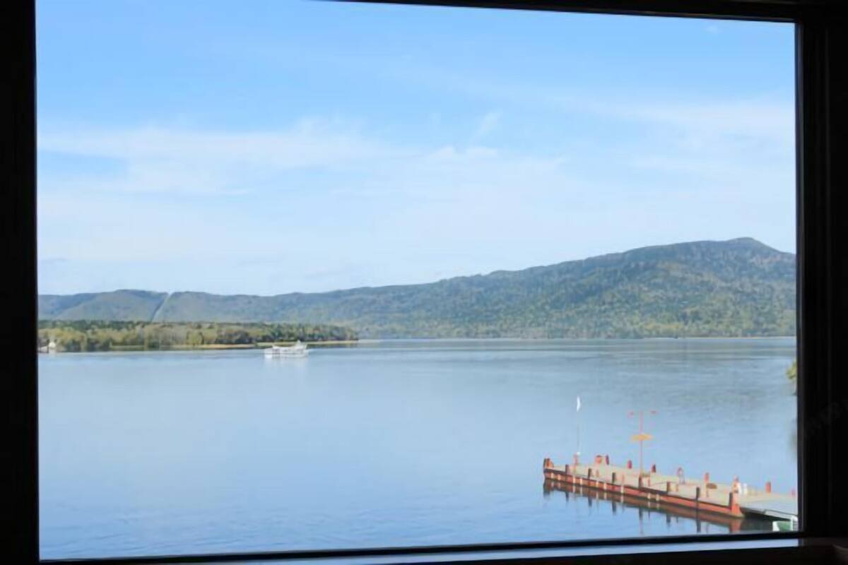 A view of a lake with a dock and mountains in the background.