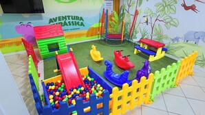 Zona de juegos infantiles con tobogán, piscina de pelotas y diversas estructuras recreativas.