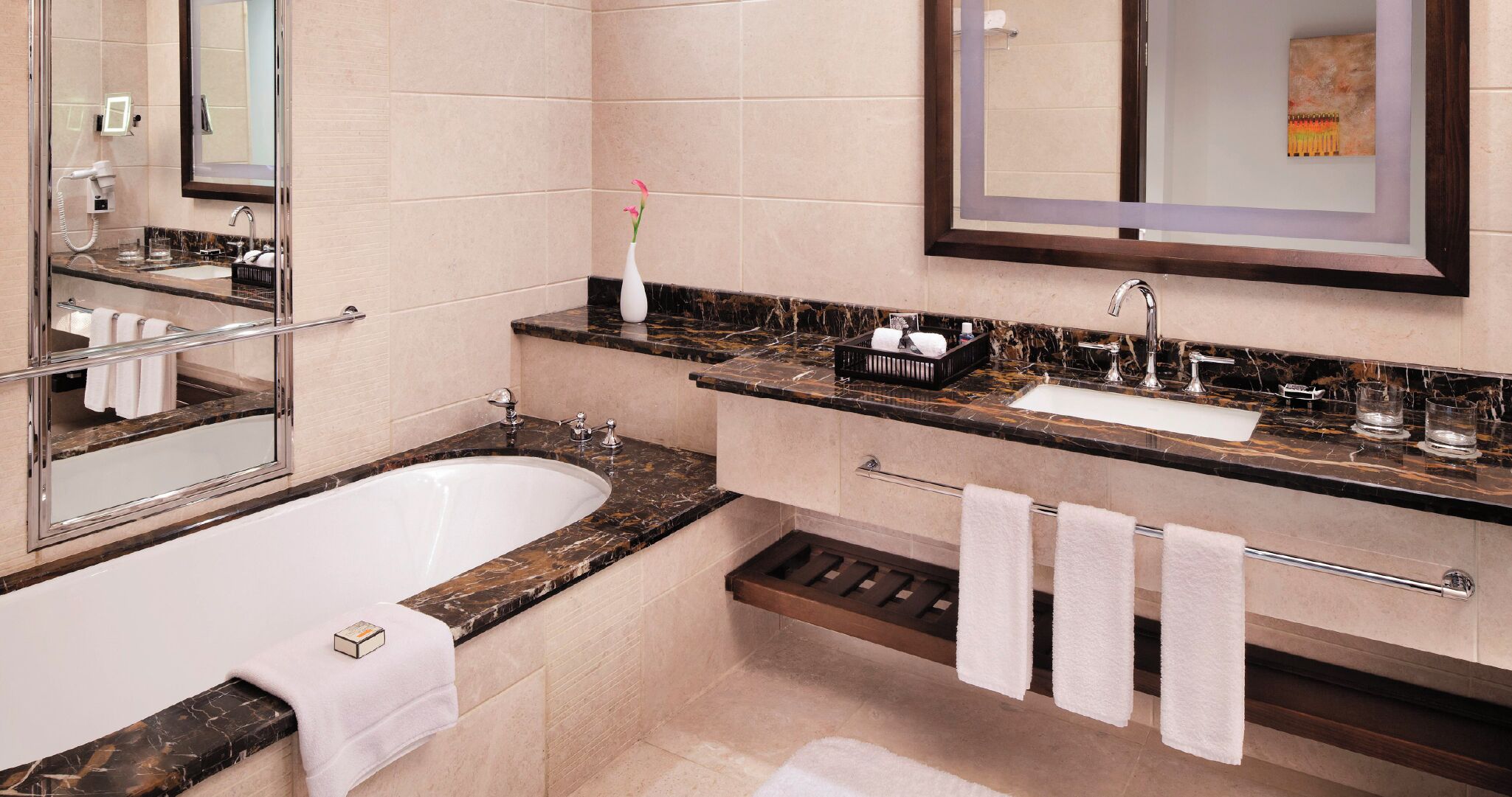A modern bathroom with a freestanding bathtub, a vanity with a sink and mirror, and a towel rack.