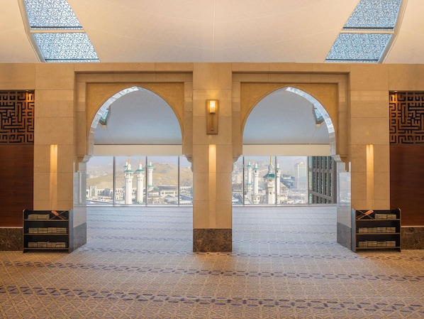 An arched entrance with a view of a cityscape through large windows. - Makkah Clock Royal Tower, A Fairmont Hotel (Makkah)