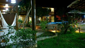A resort with a pool, outdoor seating, and lush greenery. - Pousada Pedra Torta (Itacaré)