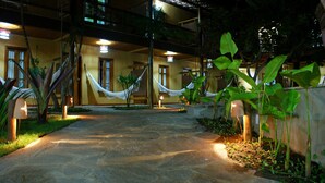 A stone pathway leading to a building with a balcony. - Pousada Pedra Torta (Itacaré)