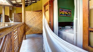 A room with a bed, a hammock, and a view of the outside. - Pousada Pedra Torta (Itacaré)