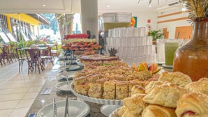 Un bufé con diversos alimentos, incluyendo pasteles, tortas y fruta.
