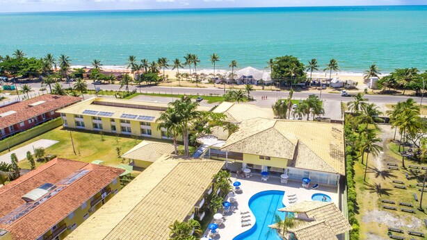 Un resort con piscina, vista al mar y palmeras.
