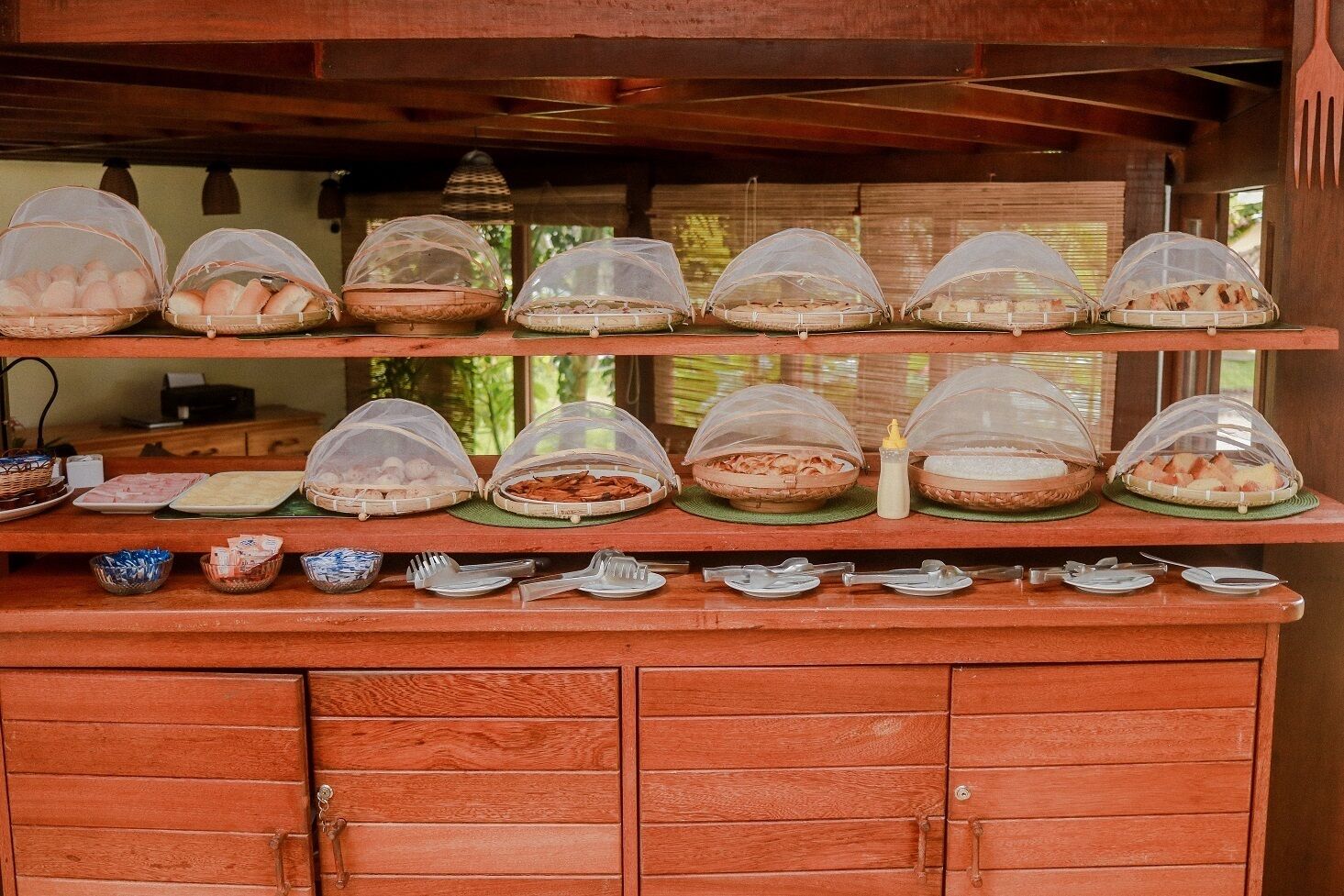 Una mesa de buffet con cestas de comida cubiertas y utensilios para servir.