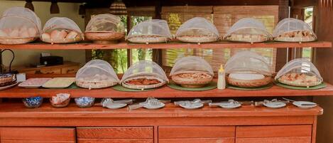 Una mesa de buffet con cestas de comida cubiertas y utensilios para servir.