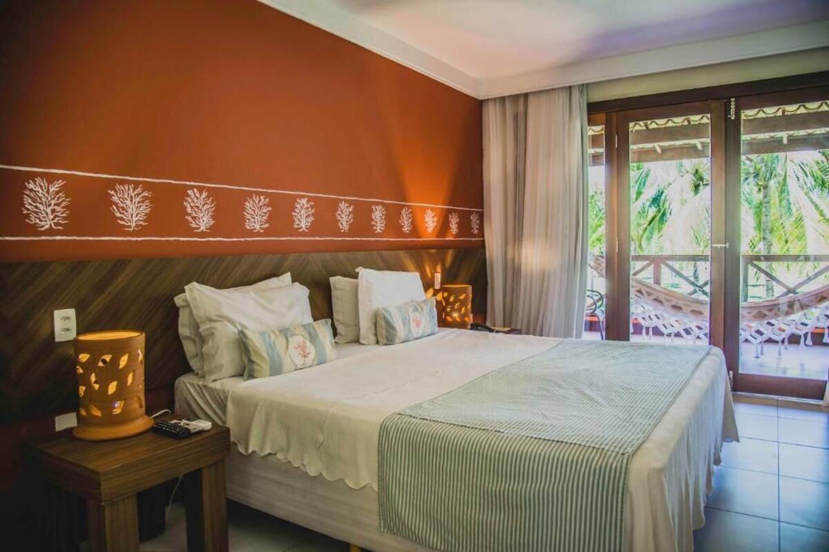 Une chambre d’hôtel avec un lit, des tables de chevet et une vue sur l’extérieur.