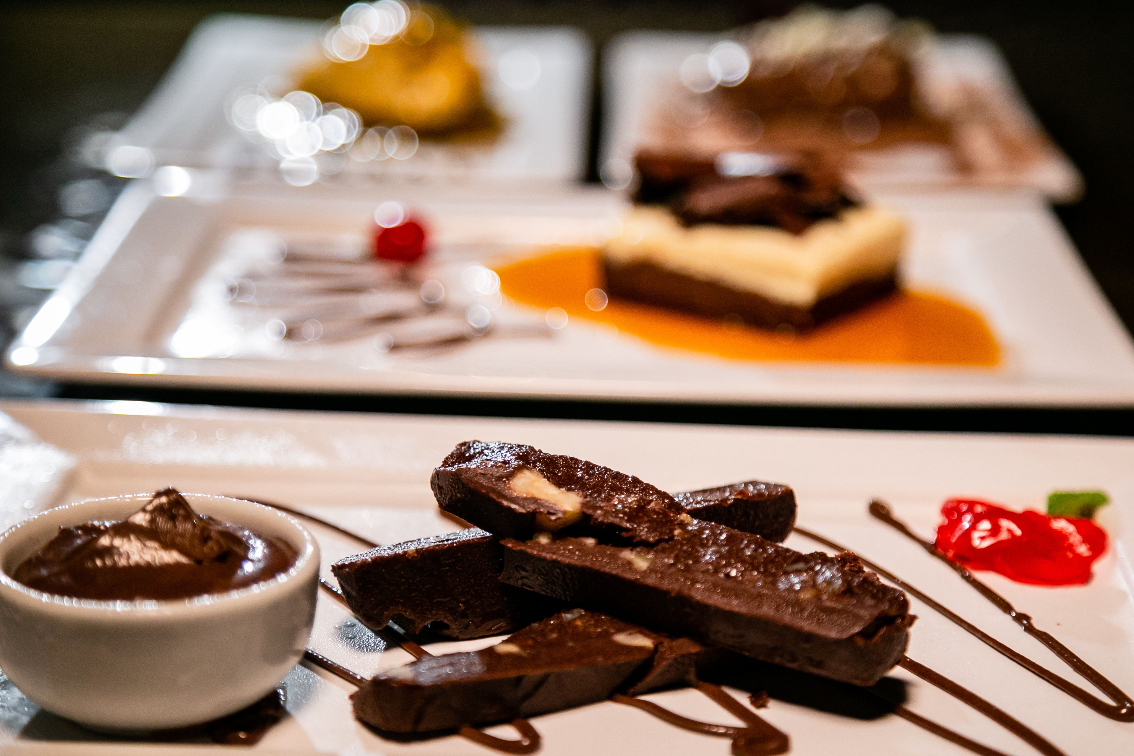 A dessert plate with chocolate pieces and sauce.