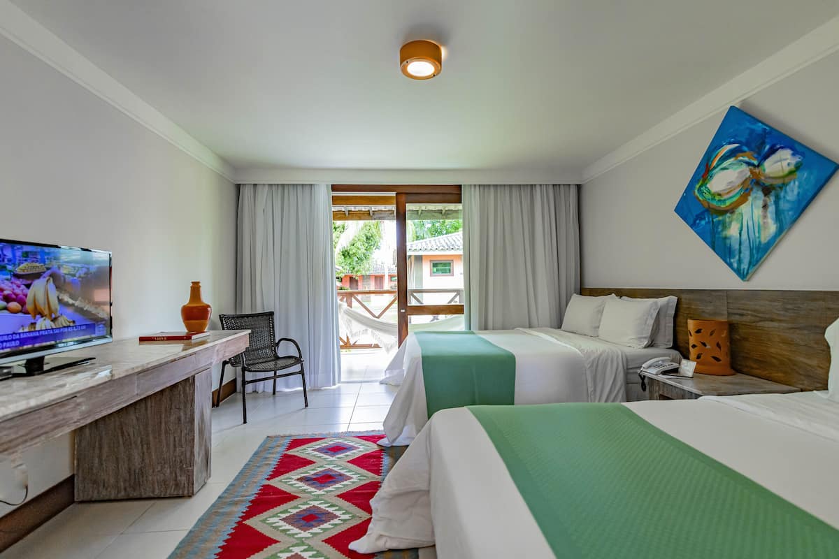 Une chambre d’hôtel avec un lit, un bureau avec une télévision, une chaise et une vue sur l’extérieur.