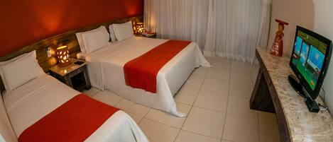 A hotel room with two beds, a TV, a desk, and a bathroom.