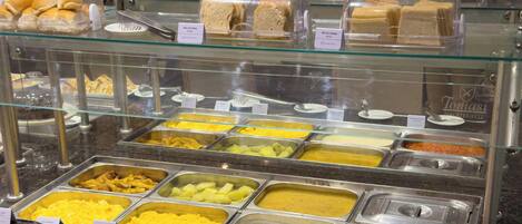 A buffet with various food items and utensils.