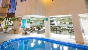 A hotel with a pool, outdoor seating, and a sign reading "OVESTAR". - Marinas Maceió Hotel (Maceió)