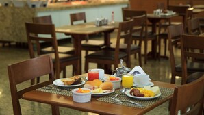 A breakfast buffet with various food items and beverages on tables. - Marinas Maceió Hotel (Maceió)
